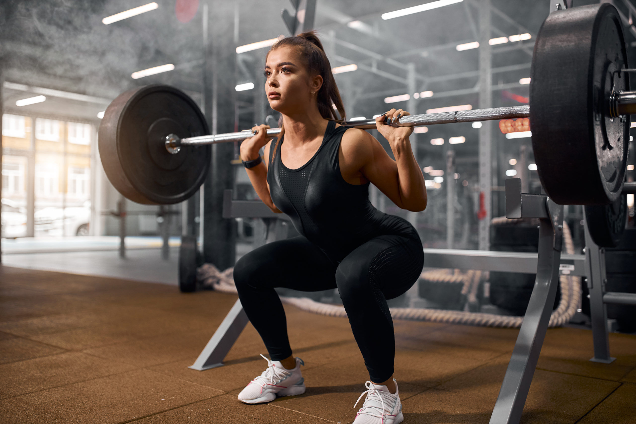 woman doing barbell squats