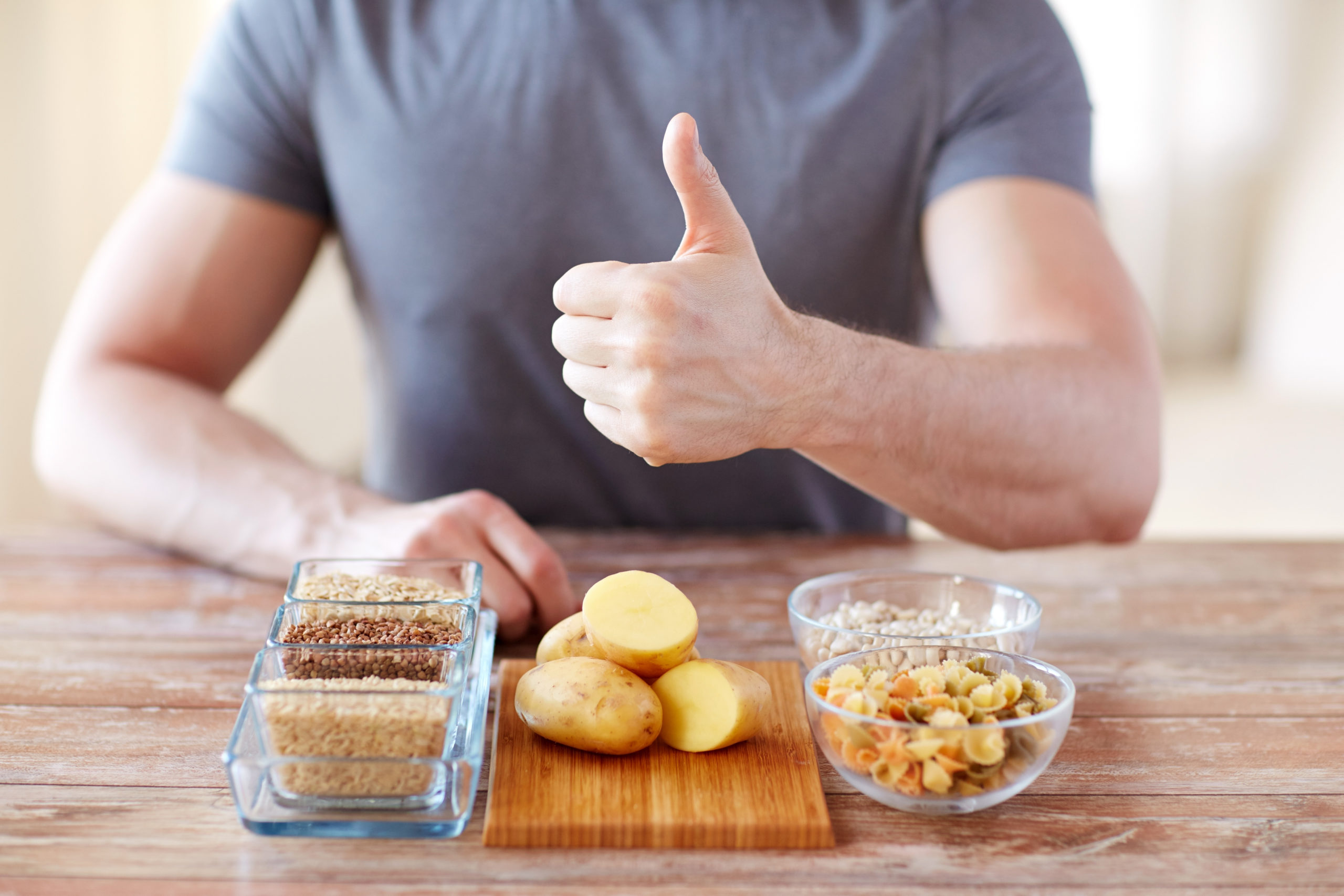 man showing carbs bread potatoes cereal