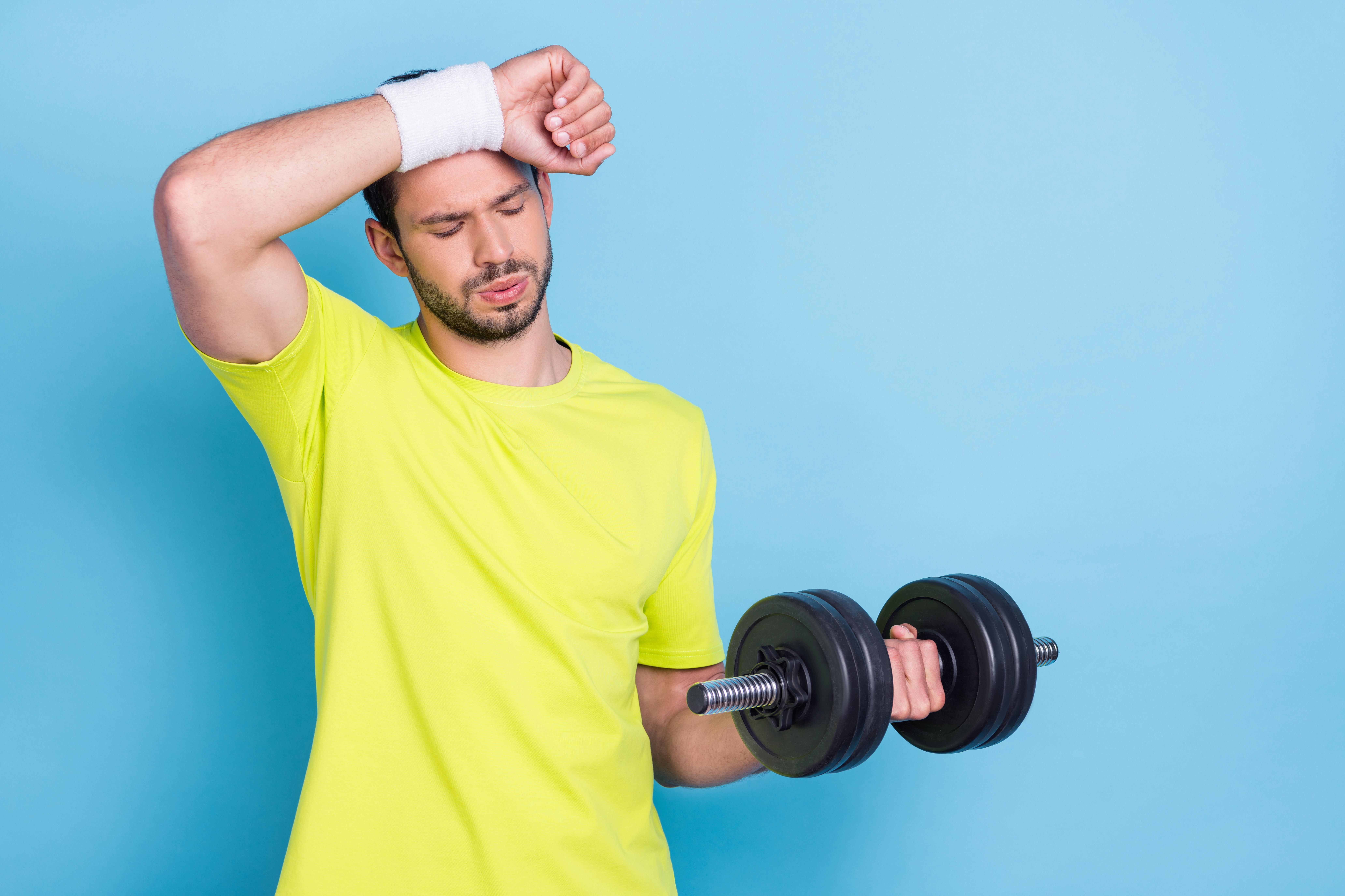 man struggling with dumbbell