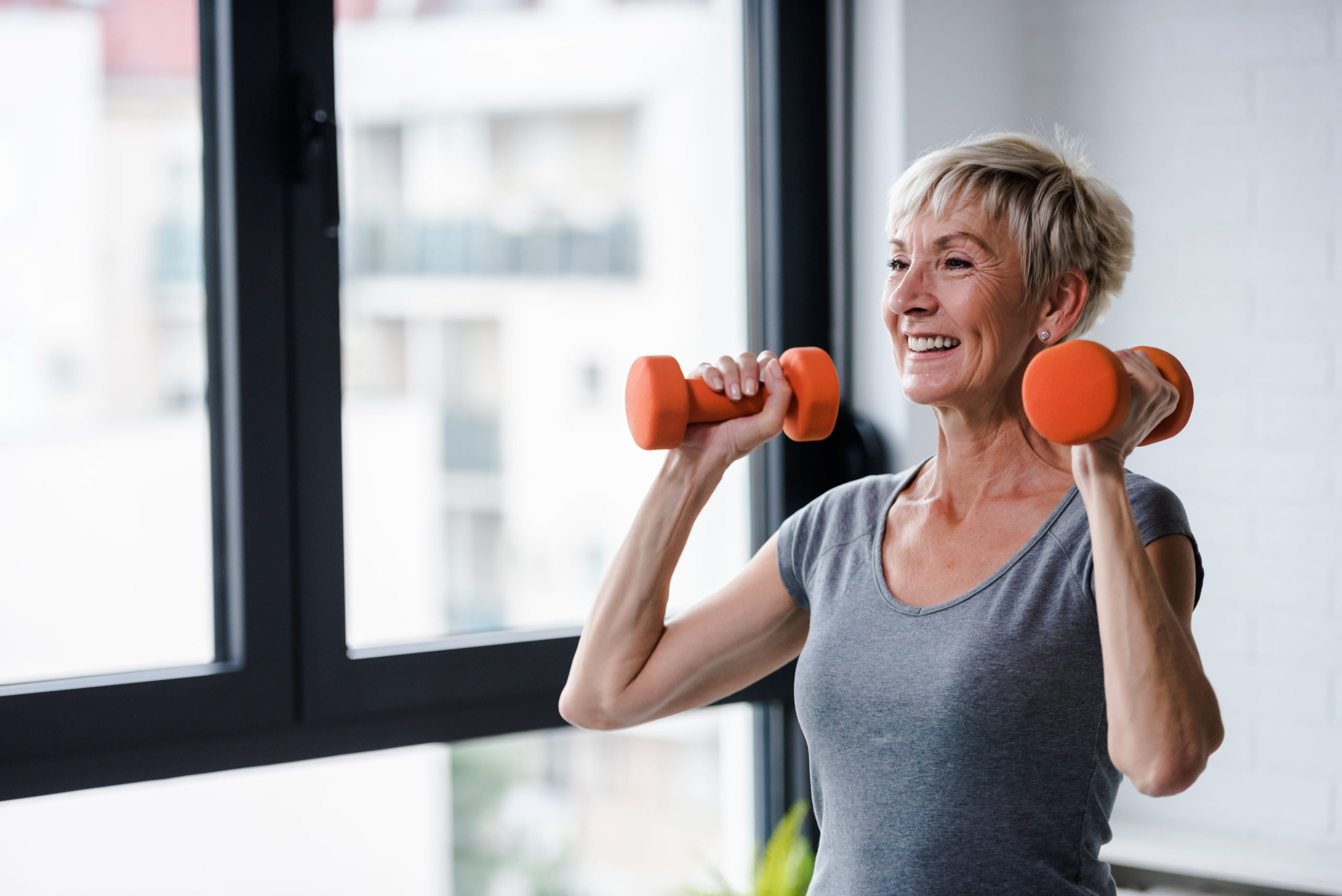older woman training with weights strength